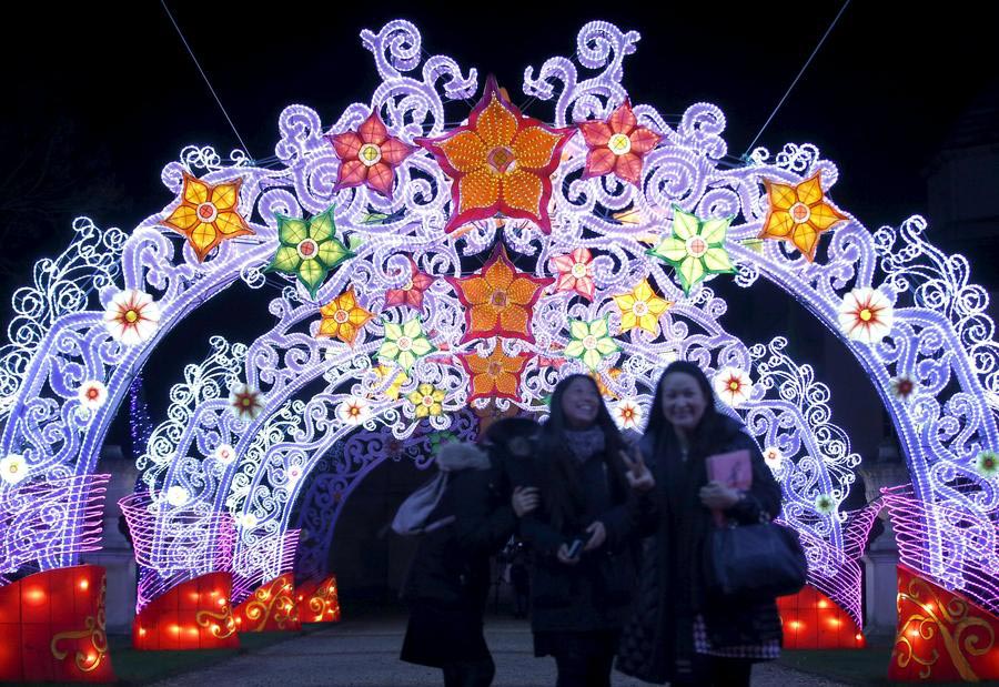 Spectacular illuminated archway entrance at Dublin Zoo Wild Lights festival. Elaborate cathedral-like structure with purple LED framework, colorful flower lanterns in red, orange, yellow, and green. Visitors walking through the magical gateway. Chinese lantern artistry meets European festival design.