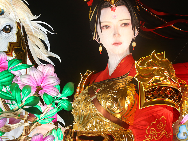Magnificent warrior goddess lantern in ornate golden armor with red robes and elaborate headdress. Detailed scale armor and ceremonial decorations demonstrate masterful Zigong silk lantern craftsmanship. Divine figure embodies Chinese martial virtue and feminine strength