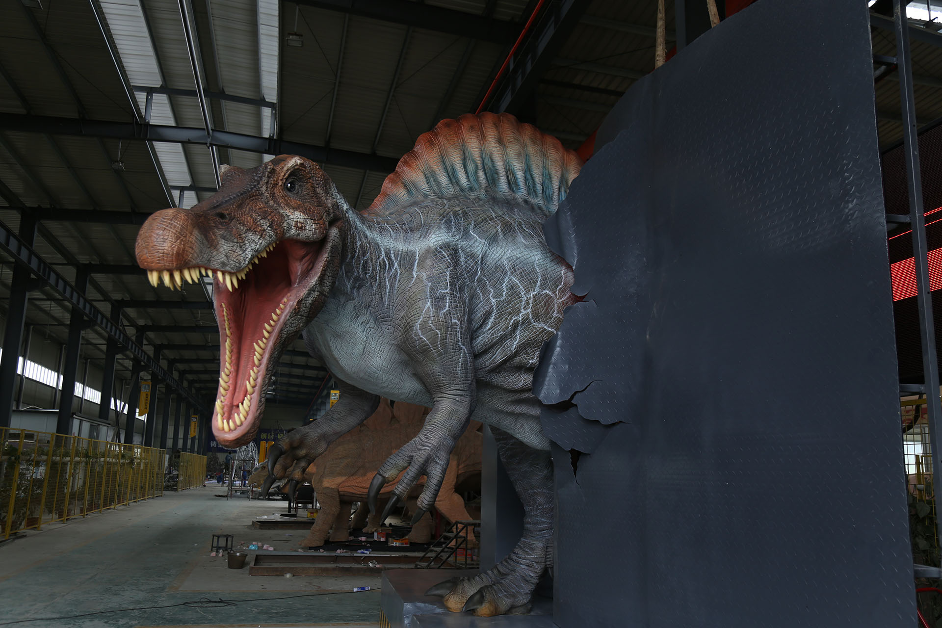 Spinosaurus animatronic model in wall-breaking pose with silicone skin technology