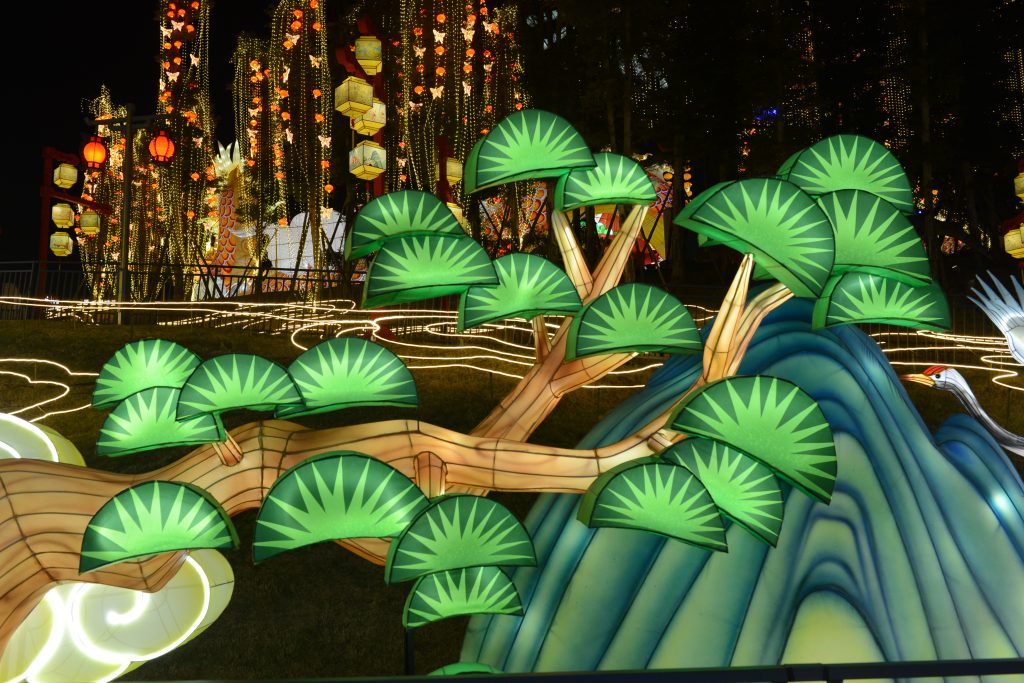 Green Chinese lantern display with pine tree and waterfall symbolizing growth, harmony, and the Wood element in Chinese Five Element color theory