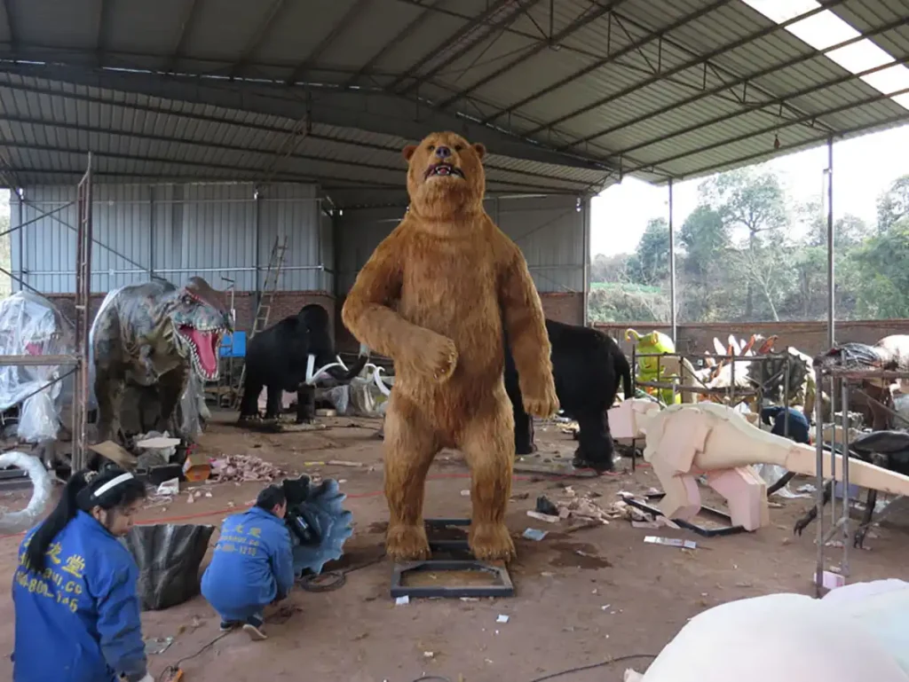 Life-size animatronic cave bear model with dark brown hand-pasted synthetic fur and pronounced shoulder hump