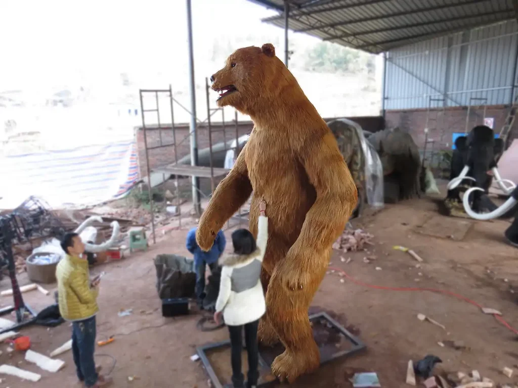 Side profile of animatronic cave bear showing shoulder hump body and leg structure