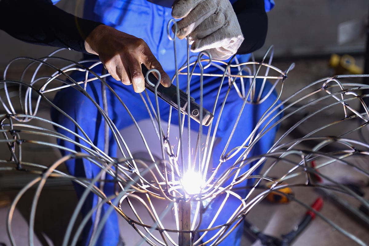 Custom lantern design process — manufacturer installing LED modules inside a steel frame during lantern fabrication