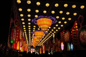 Walk-through Chinese lantern corridor with hundreds of hanging lanterns, stacked tower centerpieces and cloud dragon LED motifs