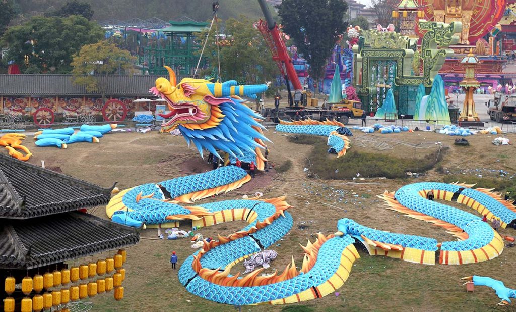 Crane installing giant Chinese dragon lantern on-site at festival venue — large scale professional lantern festival installation