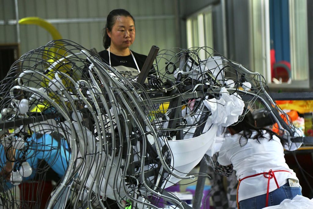 Master artisan hand-stretching silk over steel frame for mid-autumn lantern festival display