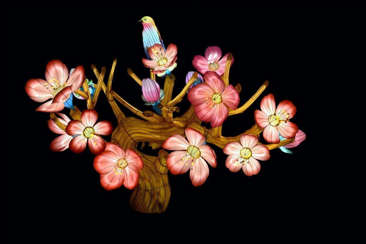 Plum blossom lantern — hand-bent blossom branch with pink silk flowers and small illuminated birds perched among the branches