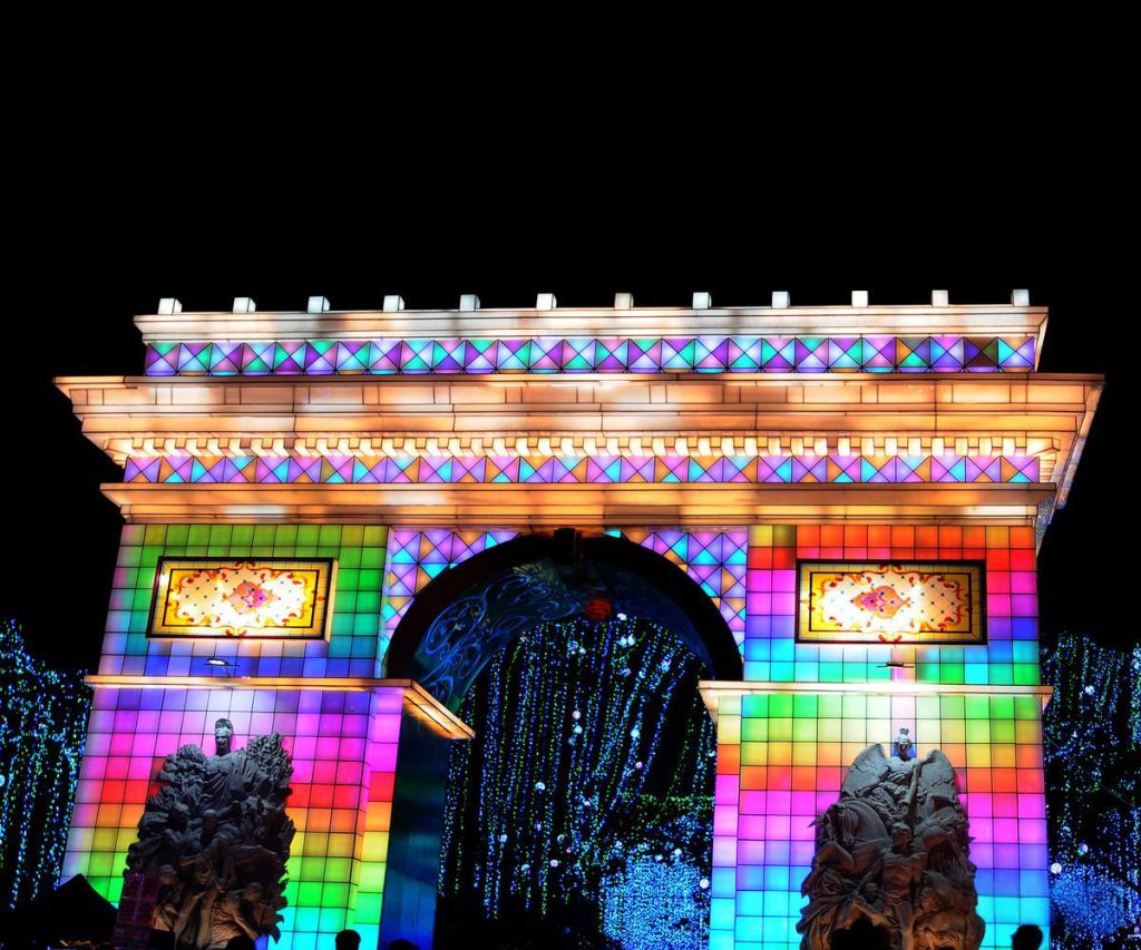 Illuminated Arc de Triomphe replica lantern with full RGB color spectrum showing all programmable LED capabilities in a Chinese lantern festival at night