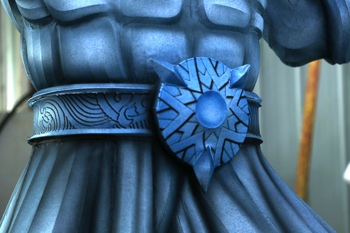 Artist hand-painting color gradients on blue densified polyester satin fabric for lantern display