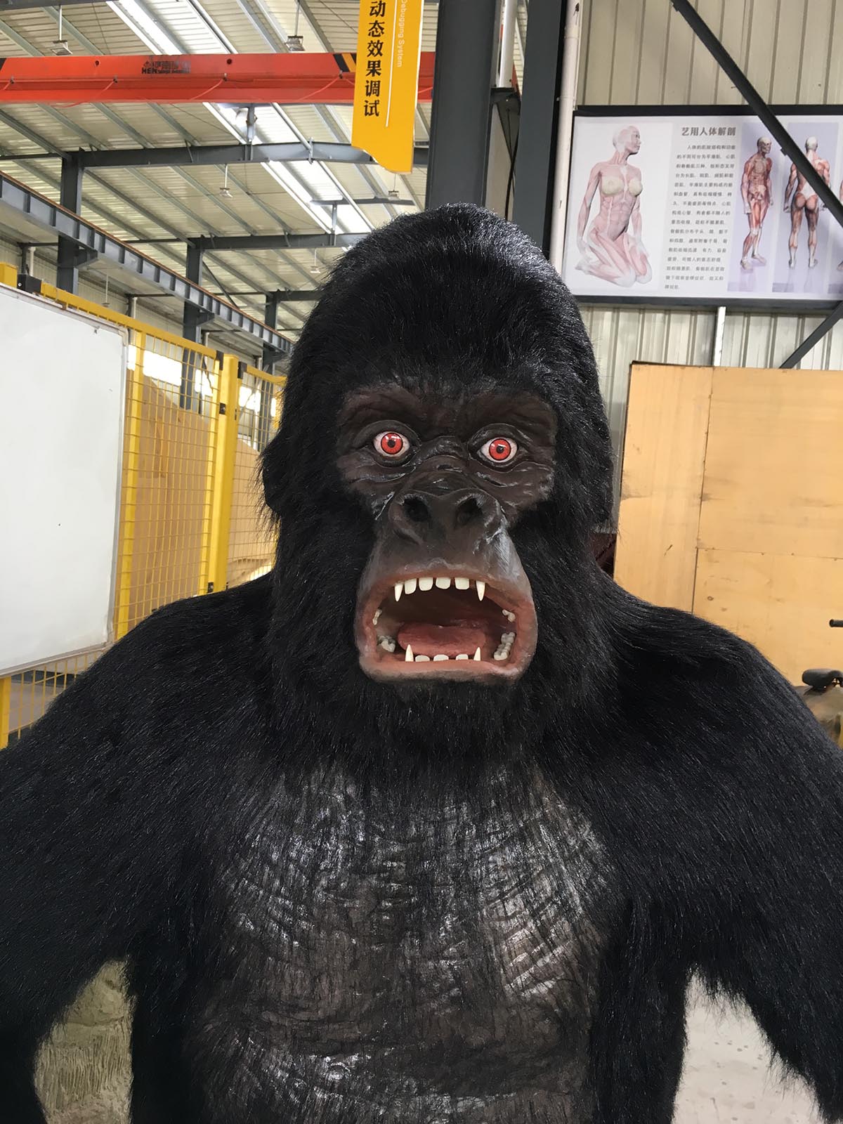 Animatronic gorilla close-up with glowing red eyes and open mouth showing hand-sculpted detail and silicone skin texture