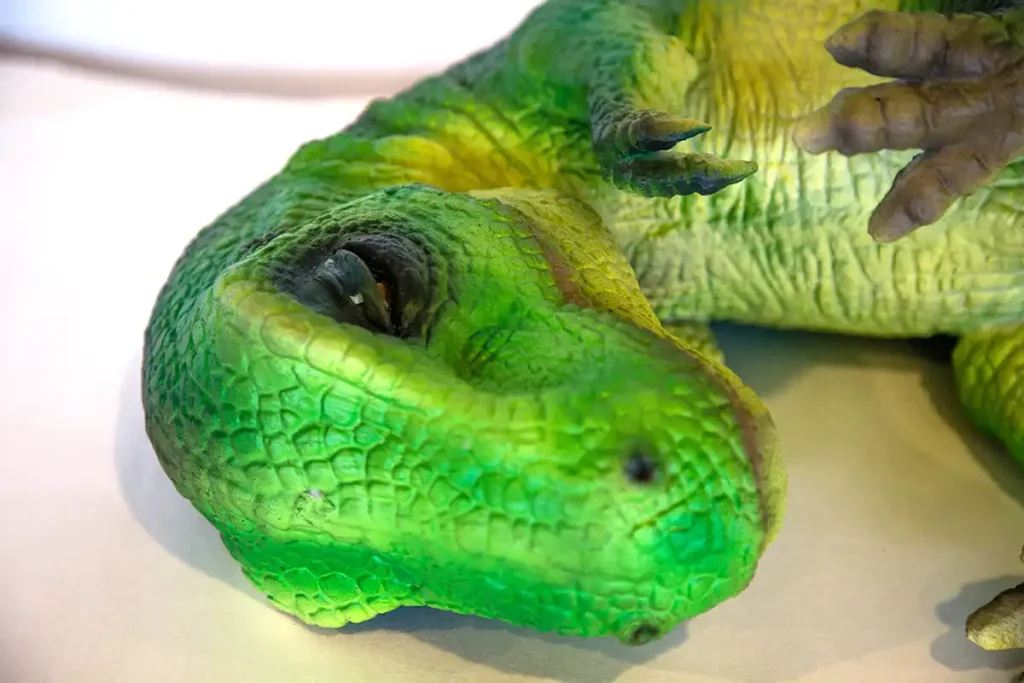 Close-up of baby dinosaur puppet head showing hand-painted scale detail and silicone skinmanufacturer