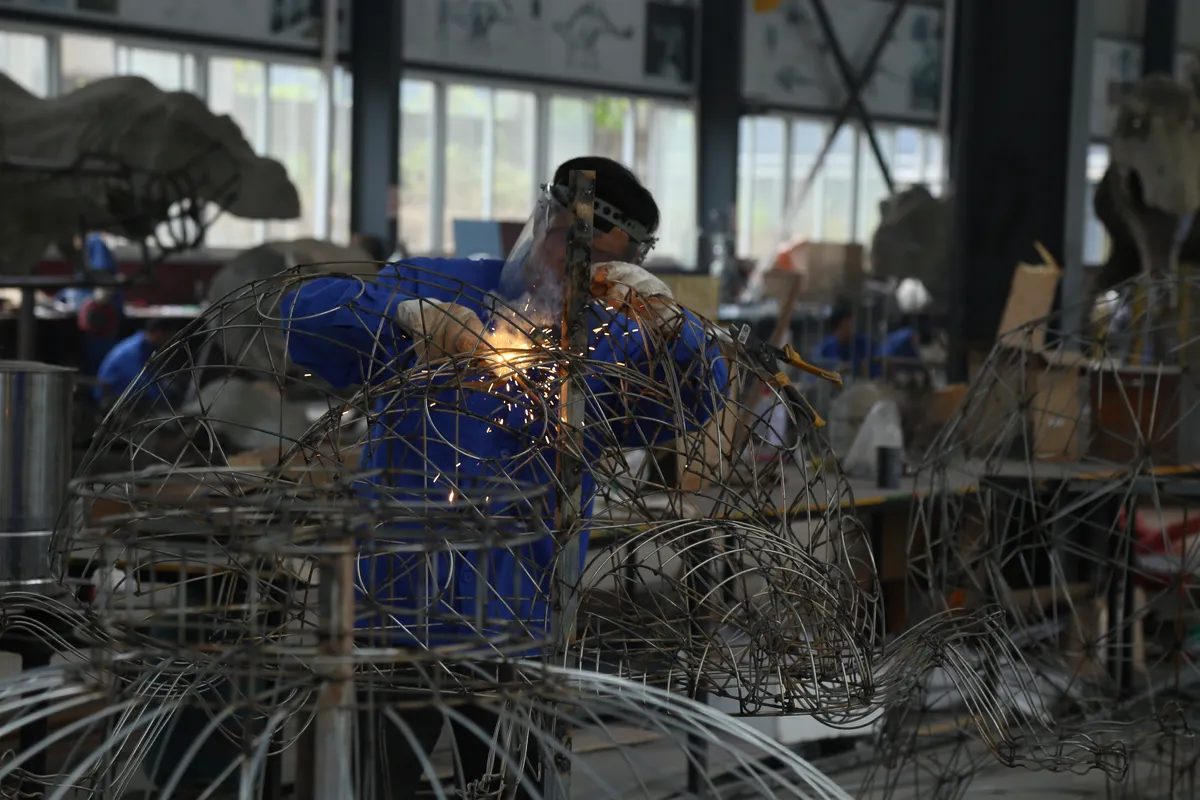 Senior artisan sculpting an animal lantern