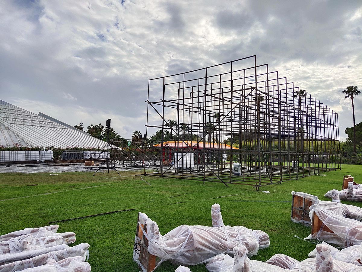 Chinese lantern installation at European botanical garden — galvanised steel frame structure assembled on lawn with silk lanterns waiting to be applied