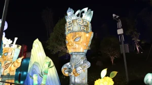 Sanxingdui bronze figure lantern with an ancient Shu culture figure in glowing silhouette against a Chinese lantern festival night sky