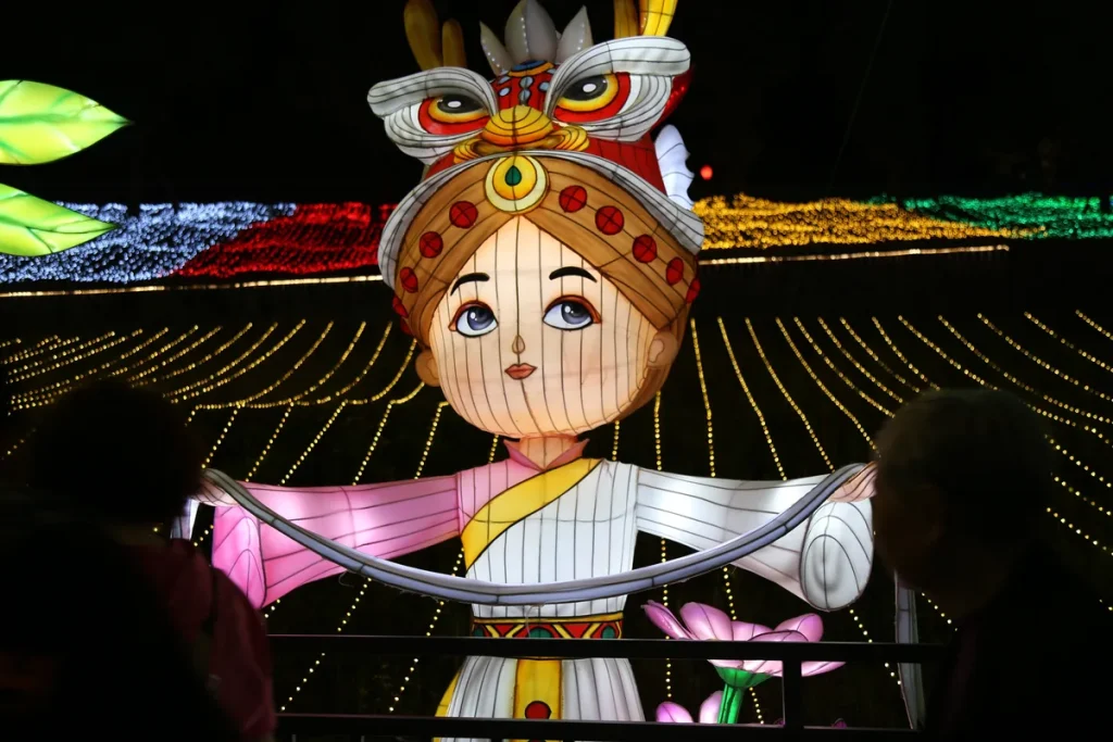 Chinese festival figure lantern with ornate headdress and radiating canopy of light strands