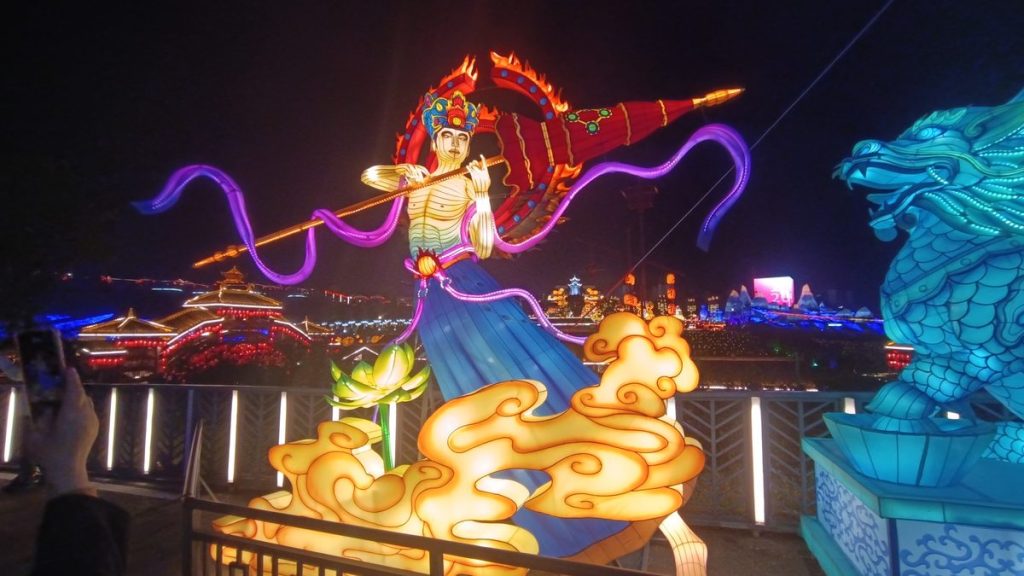 Chinese opera warrior lantern with phoenix-helm hero in flowing silk robe and golden cloud base at night festival