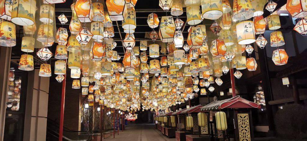 Chinese poetry lantern corridor with calligraphy and ink-painting on hexagonal palace lanterns at a night festival