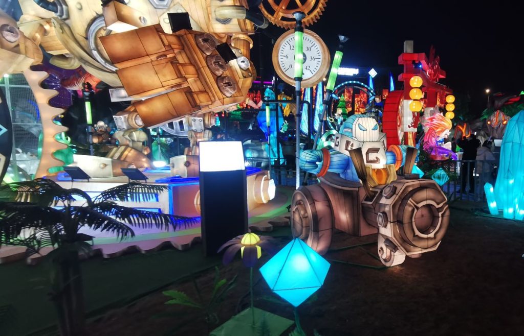 Game themed lantern scene with glowing blue crystal sculptures, character lanterns and illuminated flowers at night