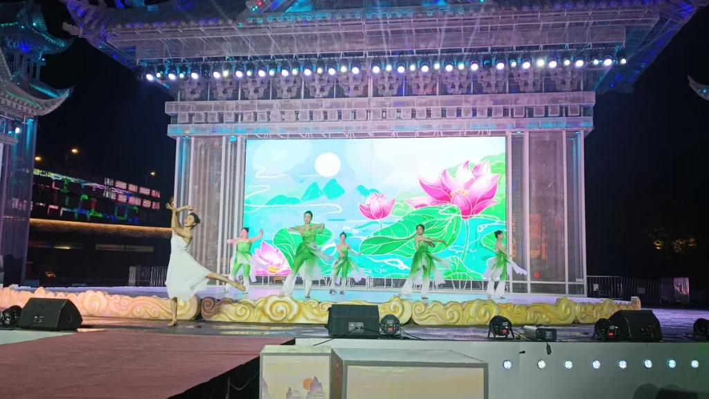 Dancers performing on a lantern festival stage in front of an illuminated lotus LED screen