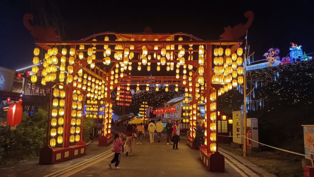 Red lantern pavilion corridor with hundreds of hanging red and amber lanterns in a Chinese wooden pavilion at a night festival