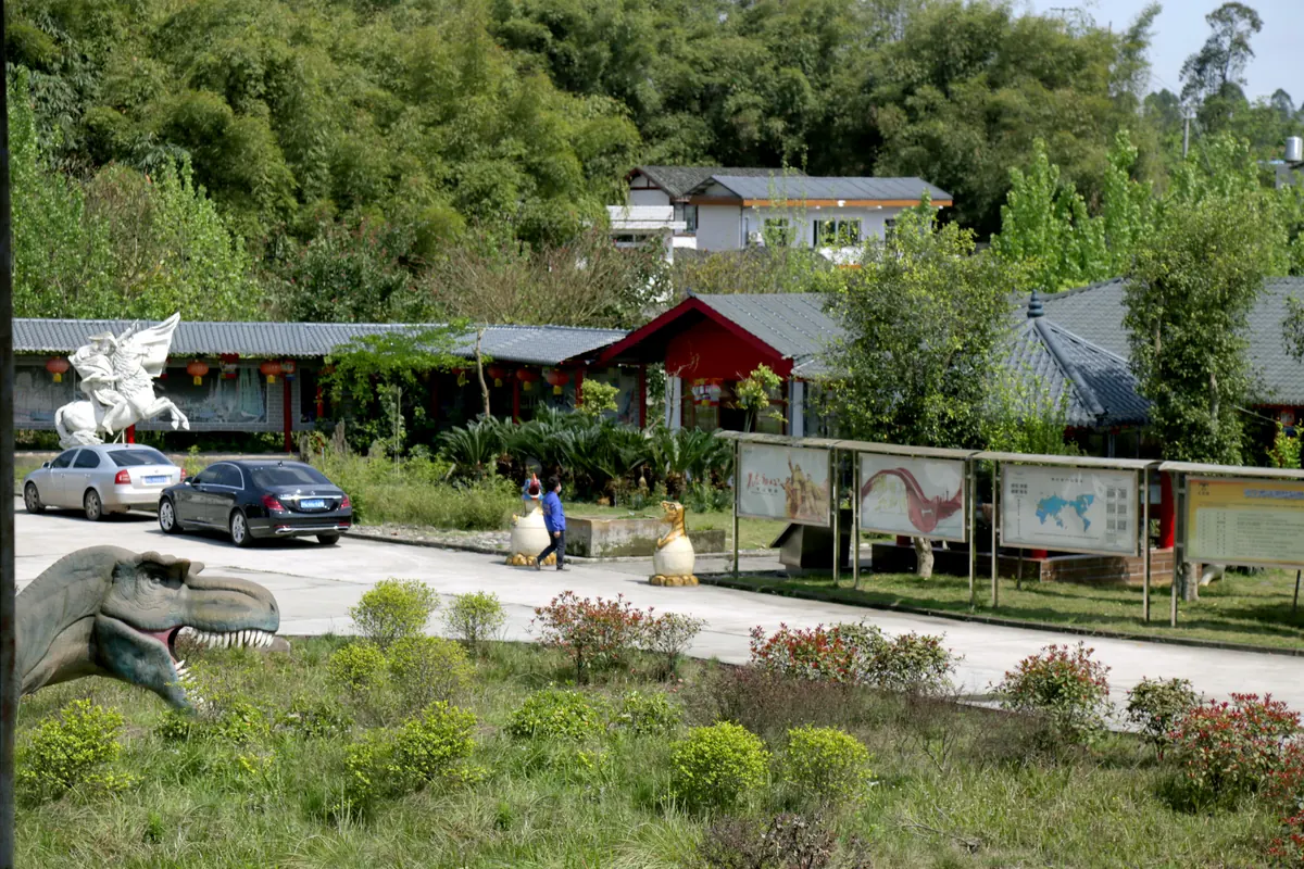 Entrance of the FestiveLanterns production base in Zigong, with a dinosaur sculpture greeting visitors at the gate